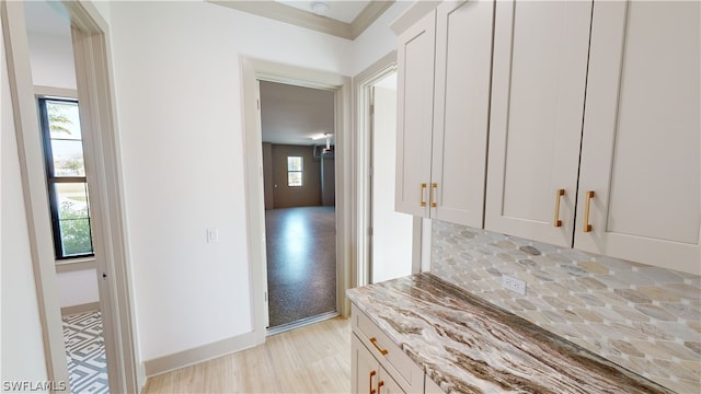 kitchen with light stone countertops, white cabinetry, and tasteful backsplash