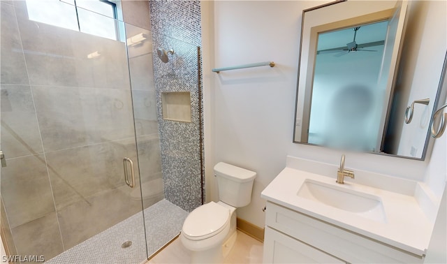 bathroom featuring a shower with shower door, oversized vanity, toilet, and ceiling fan