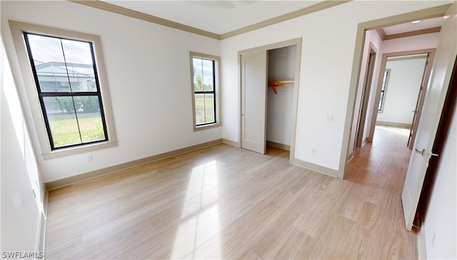 unfurnished bedroom featuring light hardwood / wood-style floors, a closet, and crown molding