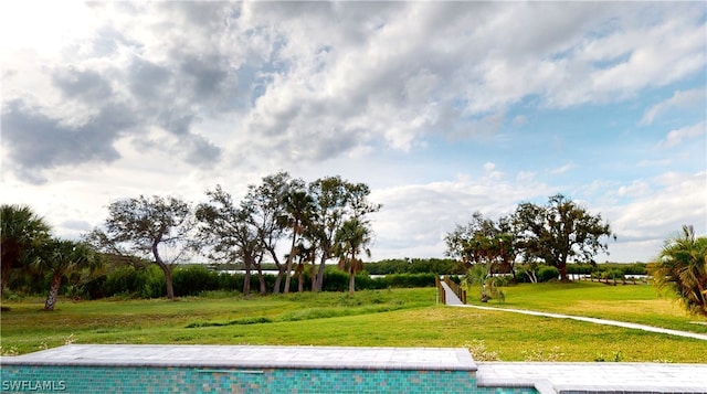 view of swimming pool with a lawn