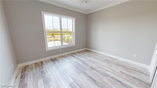 empty room featuring ornamental molding and light hardwood / wood-style flooring