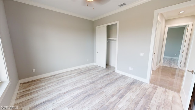 unfurnished bedroom with a closet, crown molding, and light hardwood / wood-style flooring