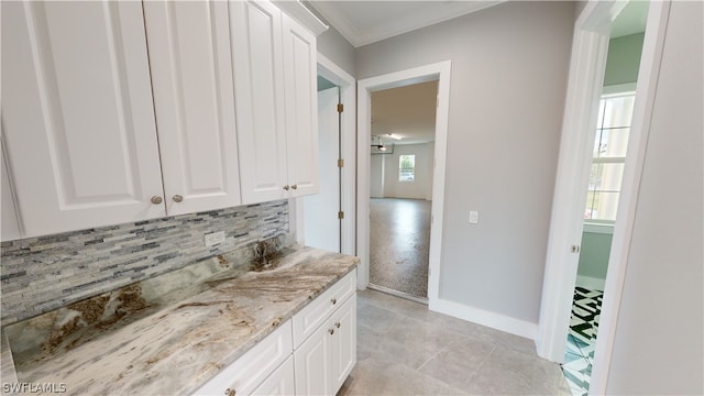 interior space with tile patterned flooring, ornamental molding, tasteful backsplash, and a healthy amount of sunlight