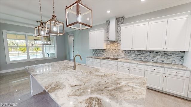 kitchen featuring white cabinets, an island with sink, and sink