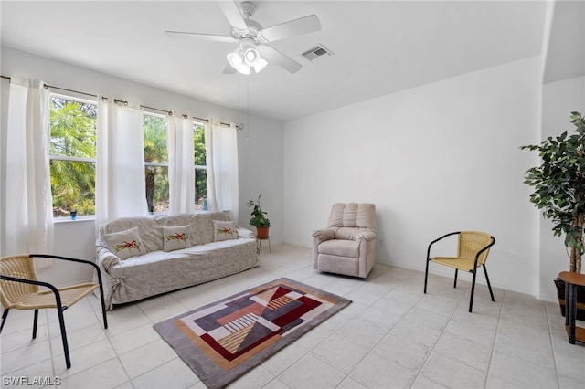 living room featuring light tile flooring and ceiling fan