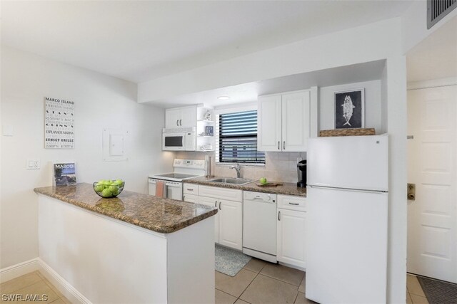 kitchen with white appliances, white cabinetry, backsplash, and sink