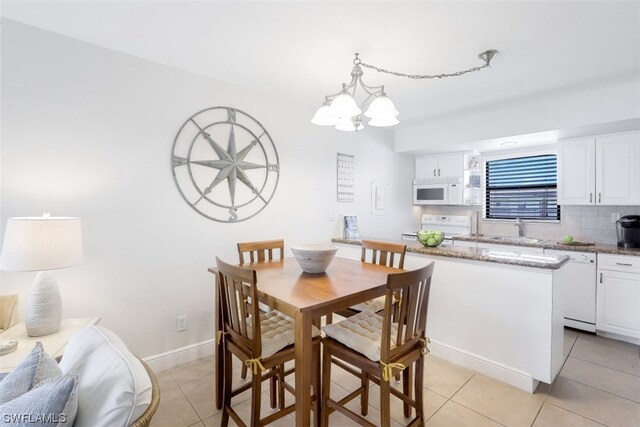 tiled dining room with an inviting chandelier and sink