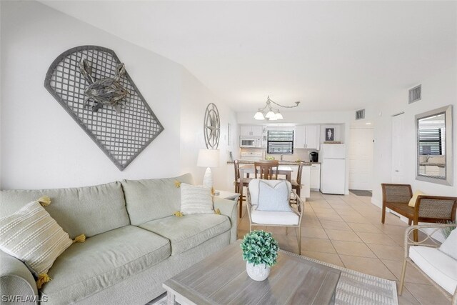 tiled living room featuring a chandelier