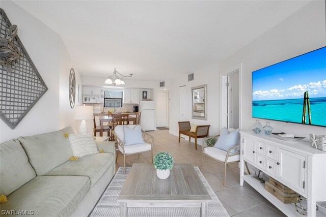 living room with a notable chandelier and light tile flooring