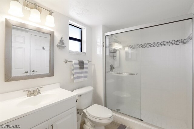 bathroom with an enclosed shower, toilet, and large vanity