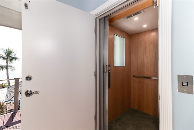 interior space with elevator and wooden walls