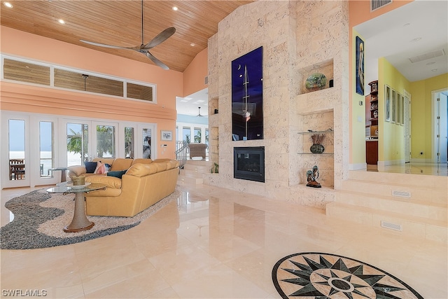 living room with a fireplace, wood ceiling, high vaulted ceiling, and ceiling fan