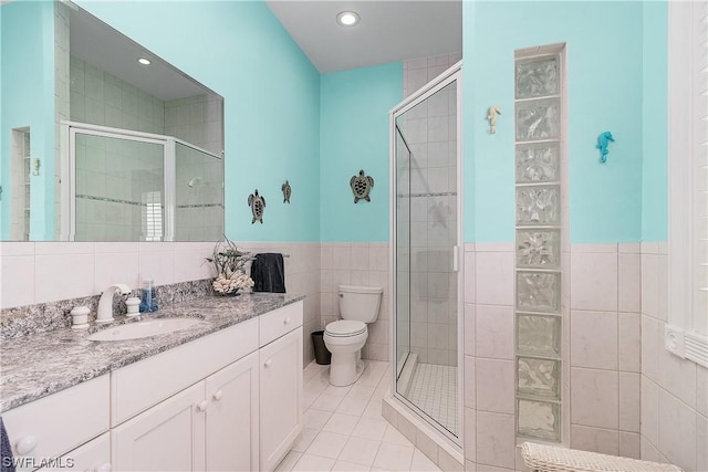 211 Kingfisher Dr, Captiva, FL 33924 - full bathroom featuring vanity, a stall shower, tile patterned flooring, toilet, and tile walls