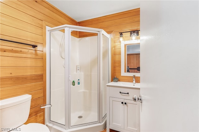 bathroom with vanity, toilet, wooden walls, and walk in shower