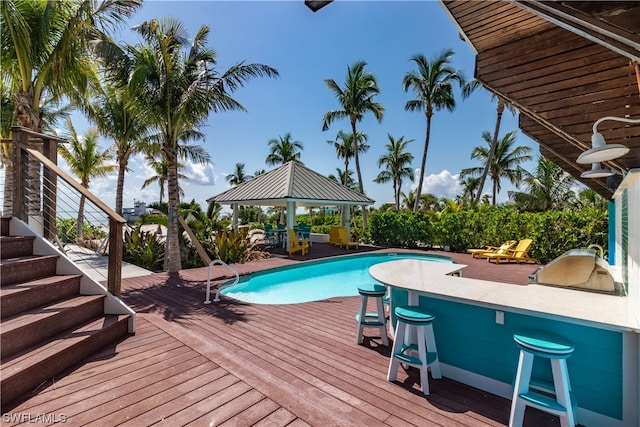 view of swimming pool with a gazebo, a wooden deck, and exterior bar