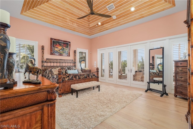 bedroom featuring multiple windows, wood ceiling, access to exterior, and light hardwood / wood-style flooring