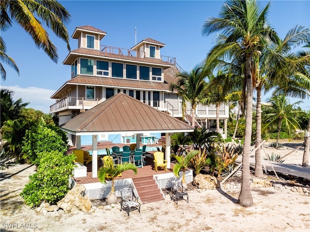 back of property featuring a balcony and a wooden deck