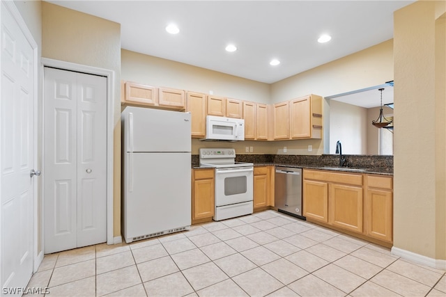 kitchen featuring white appliances, sink, light tile flooring, and dark stone counters