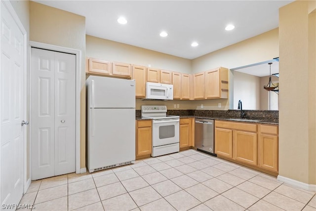 kitchen featuring sink, white appliances, light tile patterned floors, light brown cabinetry, and dark stone counters