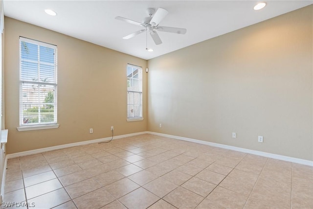 tiled spare room featuring a wealth of natural light and ceiling fan