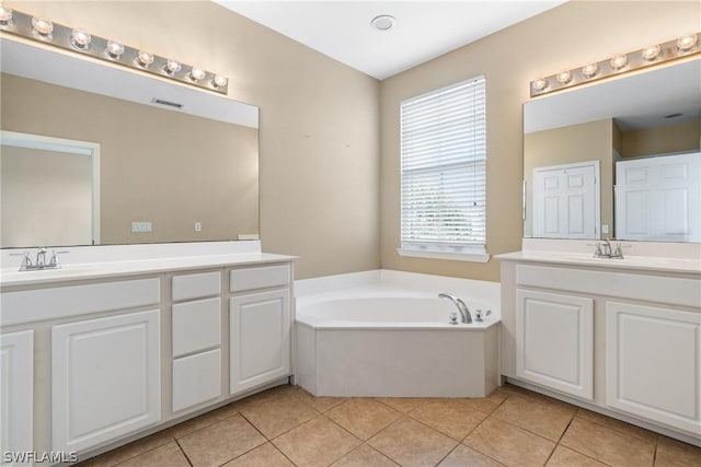 bathroom featuring tile patterned flooring, vanity, and a bath