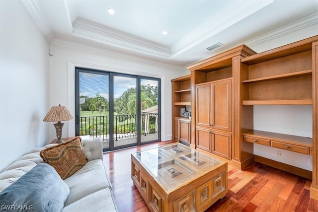 living room with a tray ceiling, light hardwood / wood-style flooring, and crown molding