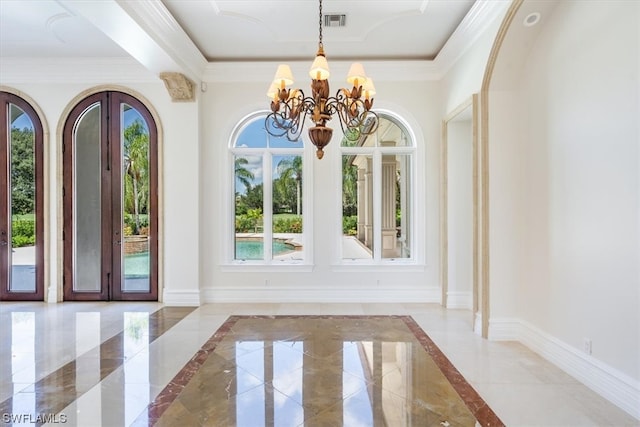 entrance foyer featuring a notable chandelier, a tray ceiling, and light tile flooring