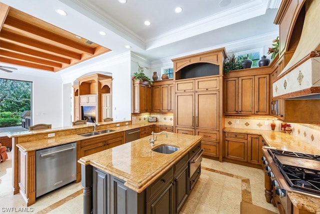 kitchen with tasteful backsplash, a kitchen island with sink, sink, and stainless steel dishwasher