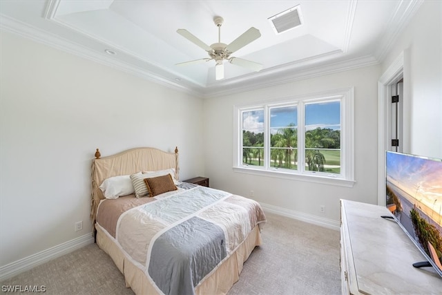 carpeted bedroom with ornamental molding, ceiling fan, and a tray ceiling