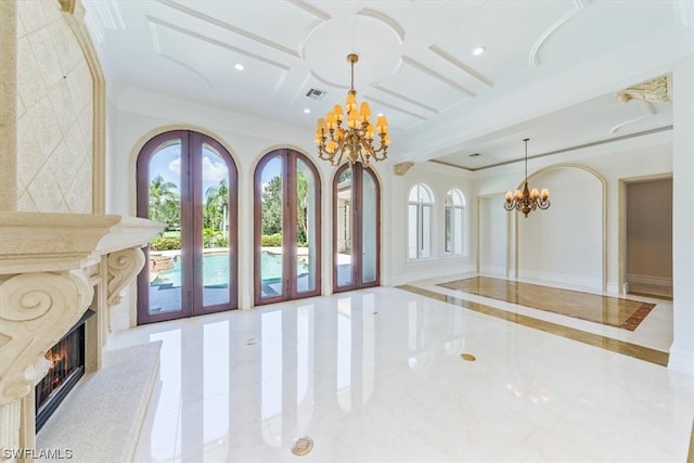 interior space with coffered ceiling, light tile flooring, french doors, a high end fireplace, and an inviting chandelier