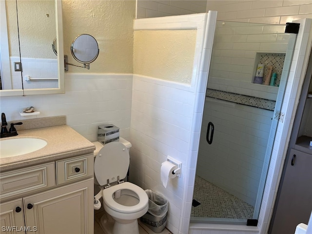 bathroom featuring tile walls, an enclosed shower, vanity, and toilet