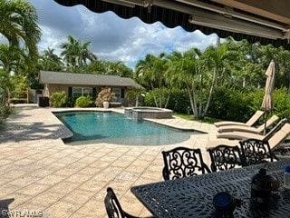 view of swimming pool featuring a patio and an in ground hot tub