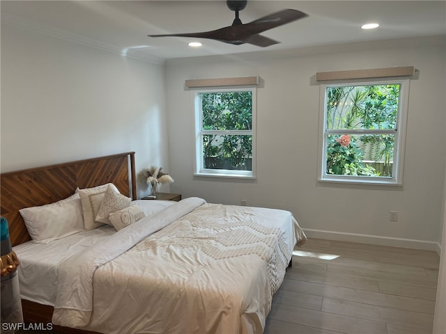 bedroom with ceiling fan, multiple windows, hardwood / wood-style flooring, and crown molding