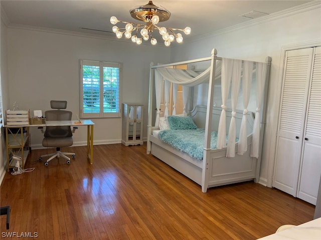 bedroom with a chandelier, ornamental molding, a closet, and wood-type flooring