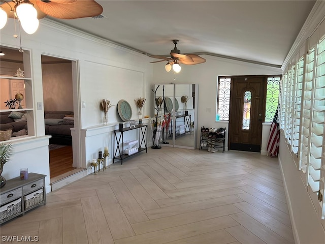 entryway featuring lofted ceiling, light parquet floors, ceiling fan, and ornamental molding