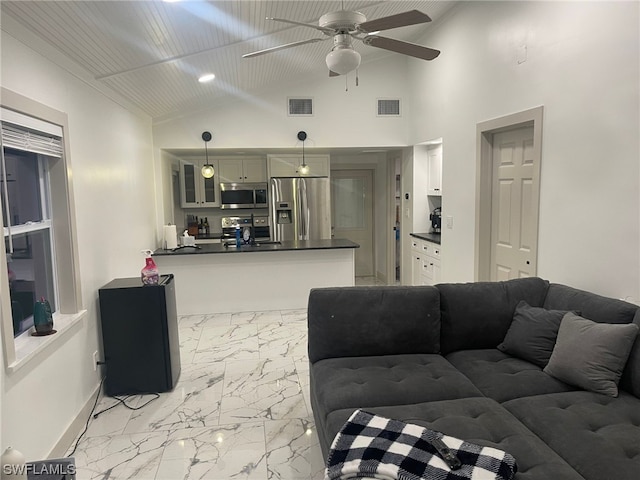 living room featuring lofted ceiling, light tile floors, and ceiling fan