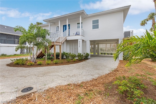 coastal inspired home featuring a carport and covered porch