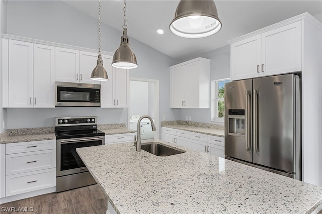 kitchen featuring pendant lighting, white cabinets, sink, vaulted ceiling, and stainless steel appliances