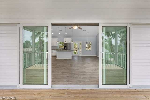 doorway to outside featuring plenty of natural light, wood walls, and wood-type flooring