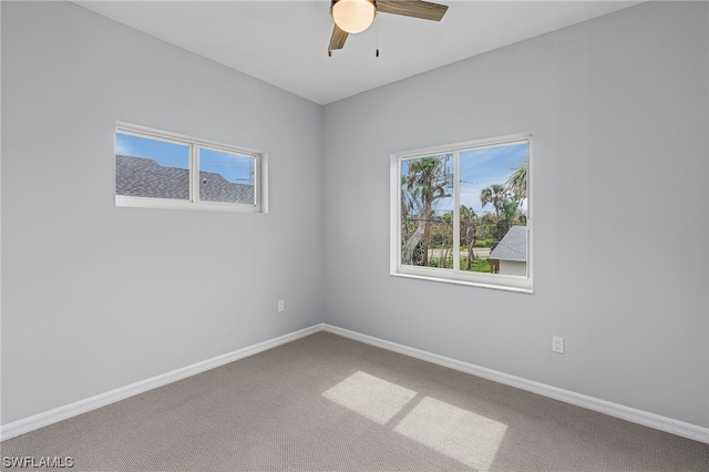 carpeted spare room featuring ceiling fan