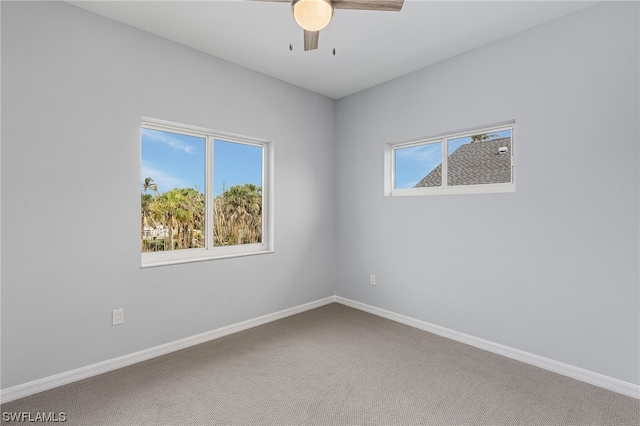 carpeted spare room featuring ceiling fan