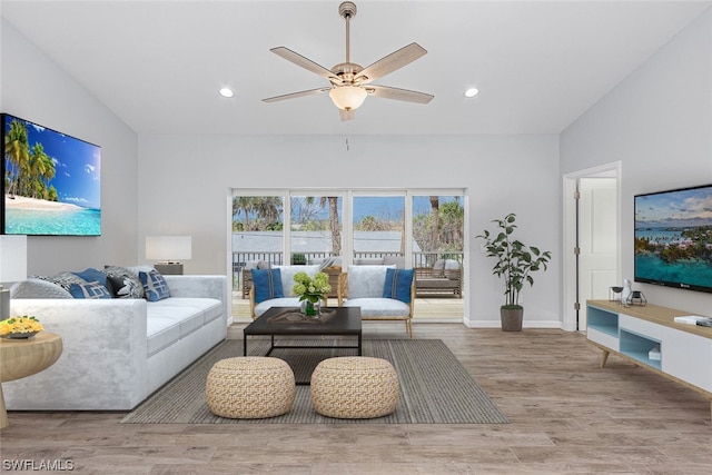 living room featuring hardwood / wood-style flooring, ceiling fan, and vaulted ceiling