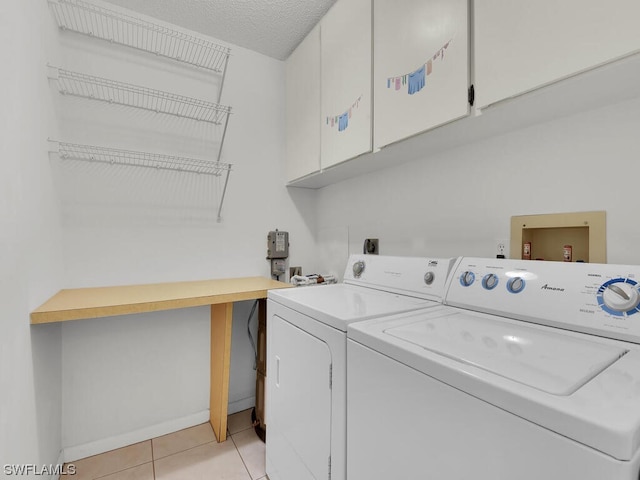 washroom with washer hookup, light tile floors, cabinets, a textured ceiling, and washing machine and dryer