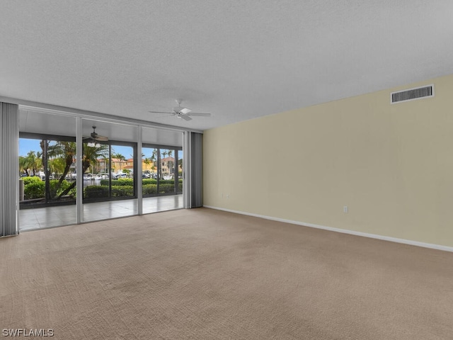 carpeted spare room with a textured ceiling and ceiling fan