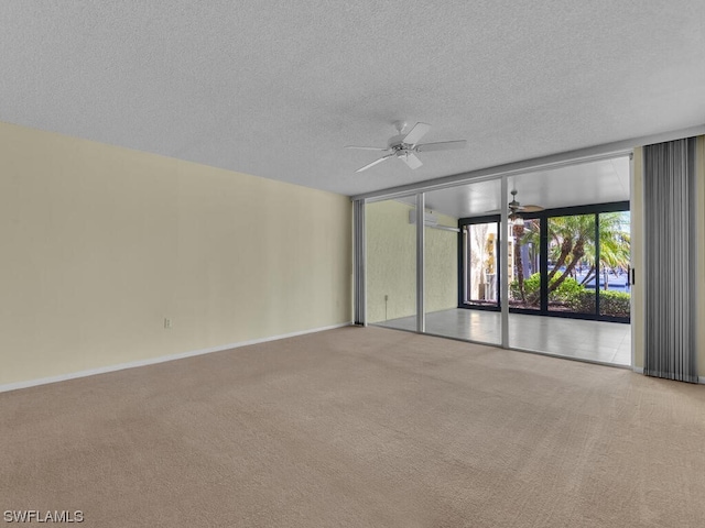 unfurnished room with expansive windows, a textured ceiling, ceiling fan, and light colored carpet