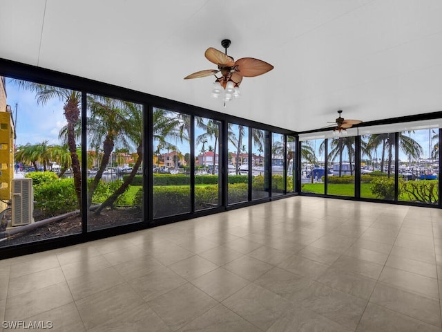 unfurnished sunroom featuring ceiling fan and a healthy amount of sunlight