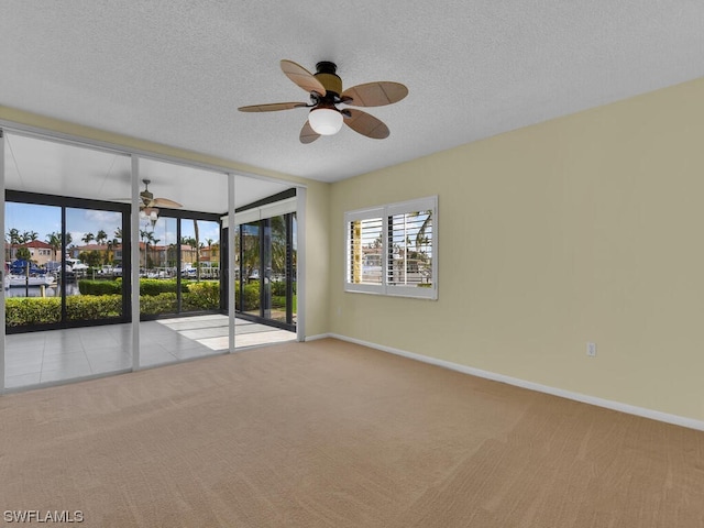 carpeted spare room featuring a textured ceiling and ceiling fan