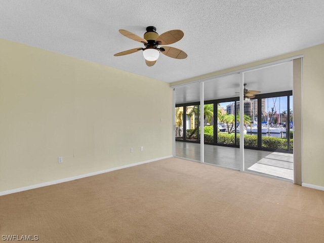 unfurnished room featuring light colored carpet, ceiling fan, and a textured ceiling