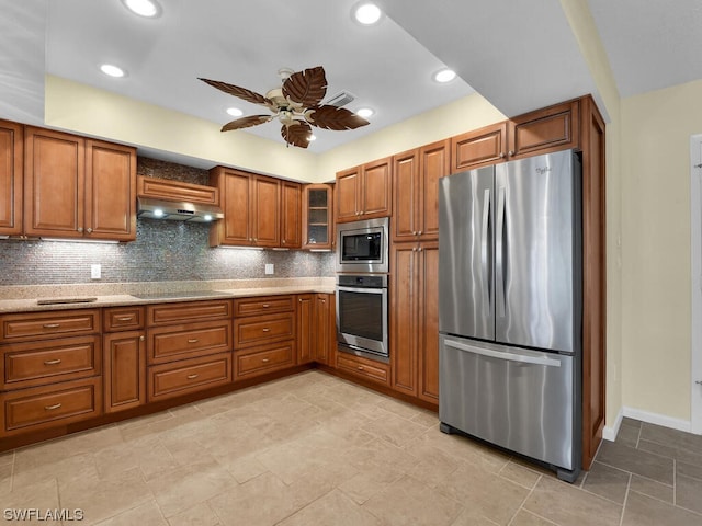 kitchen with ceiling fan, light stone counters, appliances with stainless steel finishes, backsplash, and light tile flooring