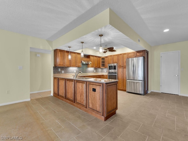 kitchen featuring kitchen peninsula, ceiling fan, appliances with stainless steel finishes, sink, and pendant lighting